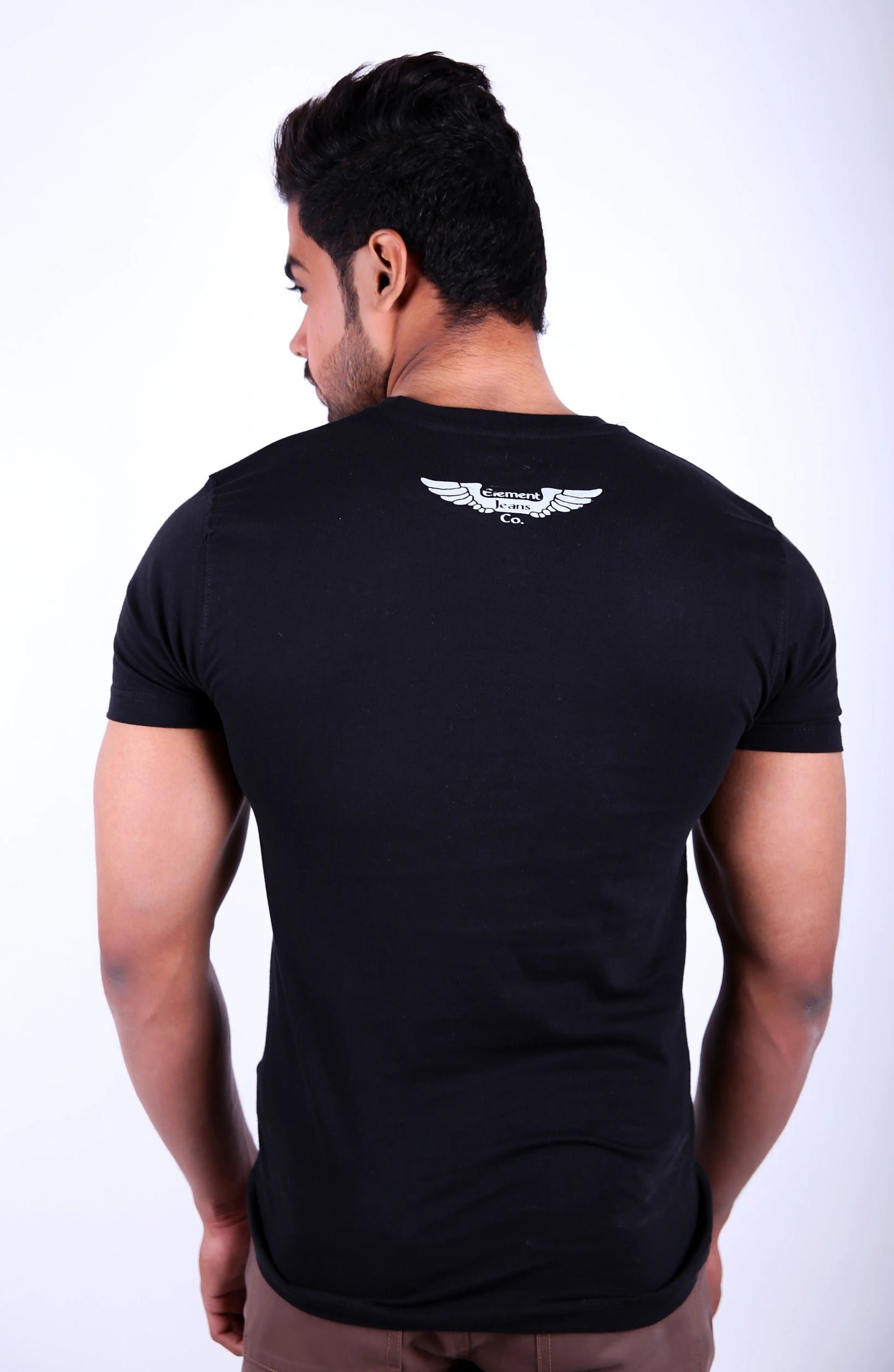Man wearing a black t-shirt with a white logo on the back against a white background