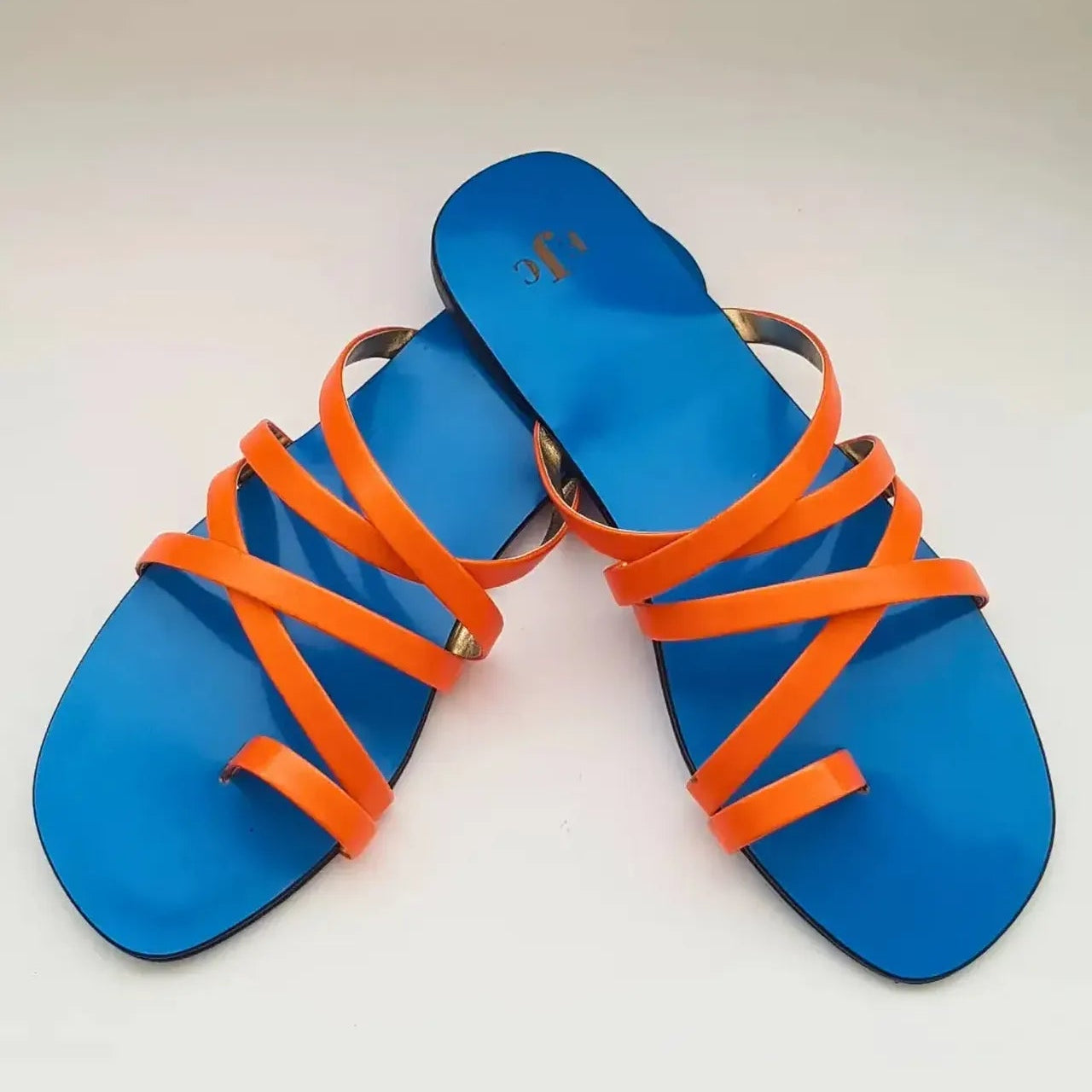 Blue sandals with orange straps on a white background