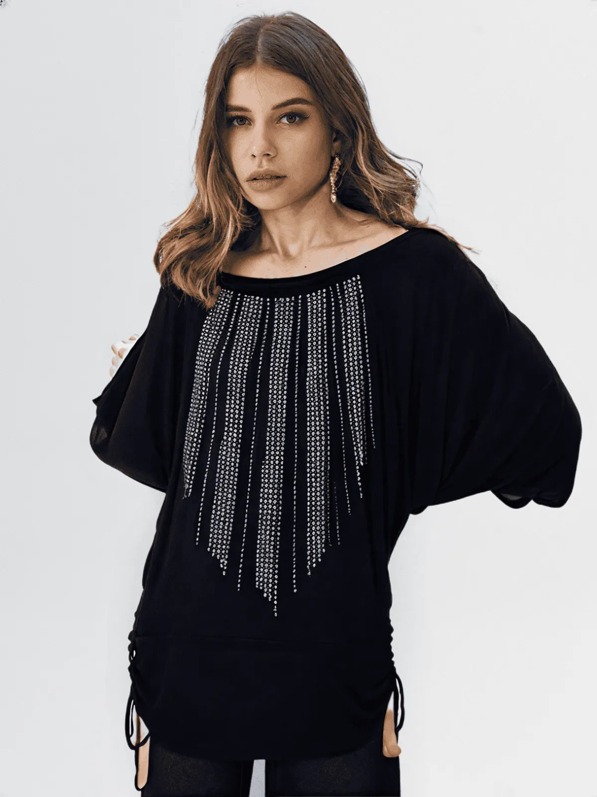 Woman wearing a black top with rhinestone embellishments on a white background
