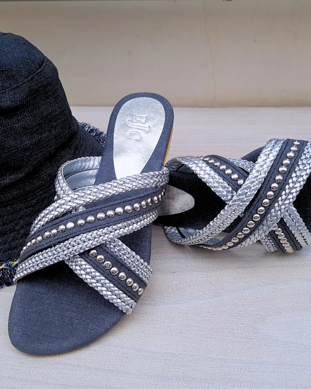 Pair of blue sandals with silver embellishments on a light background