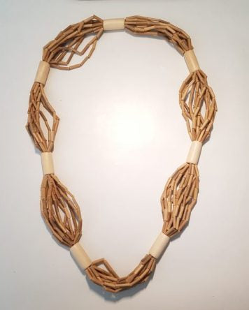 A beige wooden beaded garland necklace laid out on a plain surface.