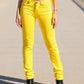 Person wearing bright yellow pants on a neutral background