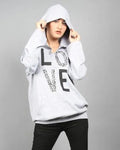 Person wearing a white hoodie with text and black pants on a gray background