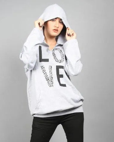 Person wearing a white hoodie with text and black pants on a gray background