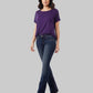 Woman wearing a purple t-shirt and blue jeans on a gray background