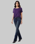Woman wearing a purple t-shirt and blue jeans on a gray background