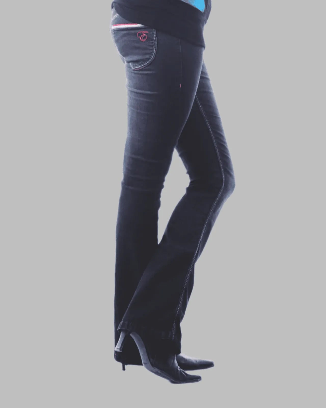Dark blue jeans worn by a person on a gray background