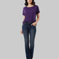 Woman wearing a purple shirt and dark blue jeans on a light gray background
