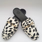 Pair of leopard print slippers with gold accents on a white background
