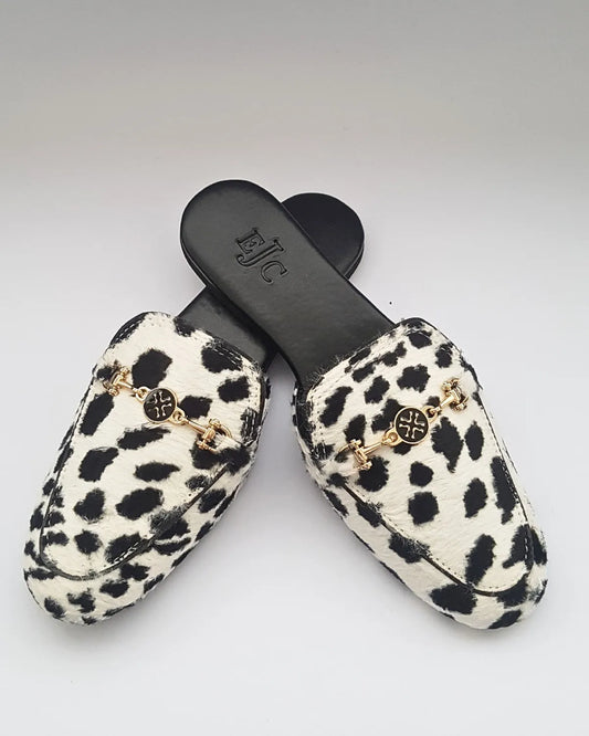 Pair of leopard print slippers with gold accents on a white background
