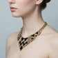 Gold and black chevron patterned necklace on a mannequin