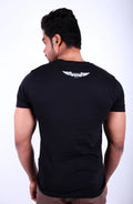 Man wearing a black t-shirt with a white logo on the back against a white background