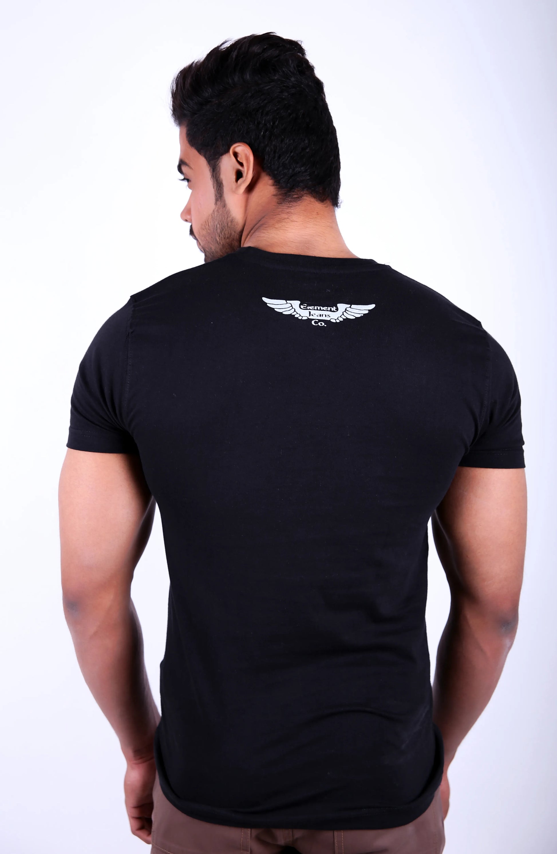 Man wearing a black t-shirt with a white logo on the back against a white background