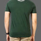Person wearing a green t-shirt with a logo on the back against a gray background