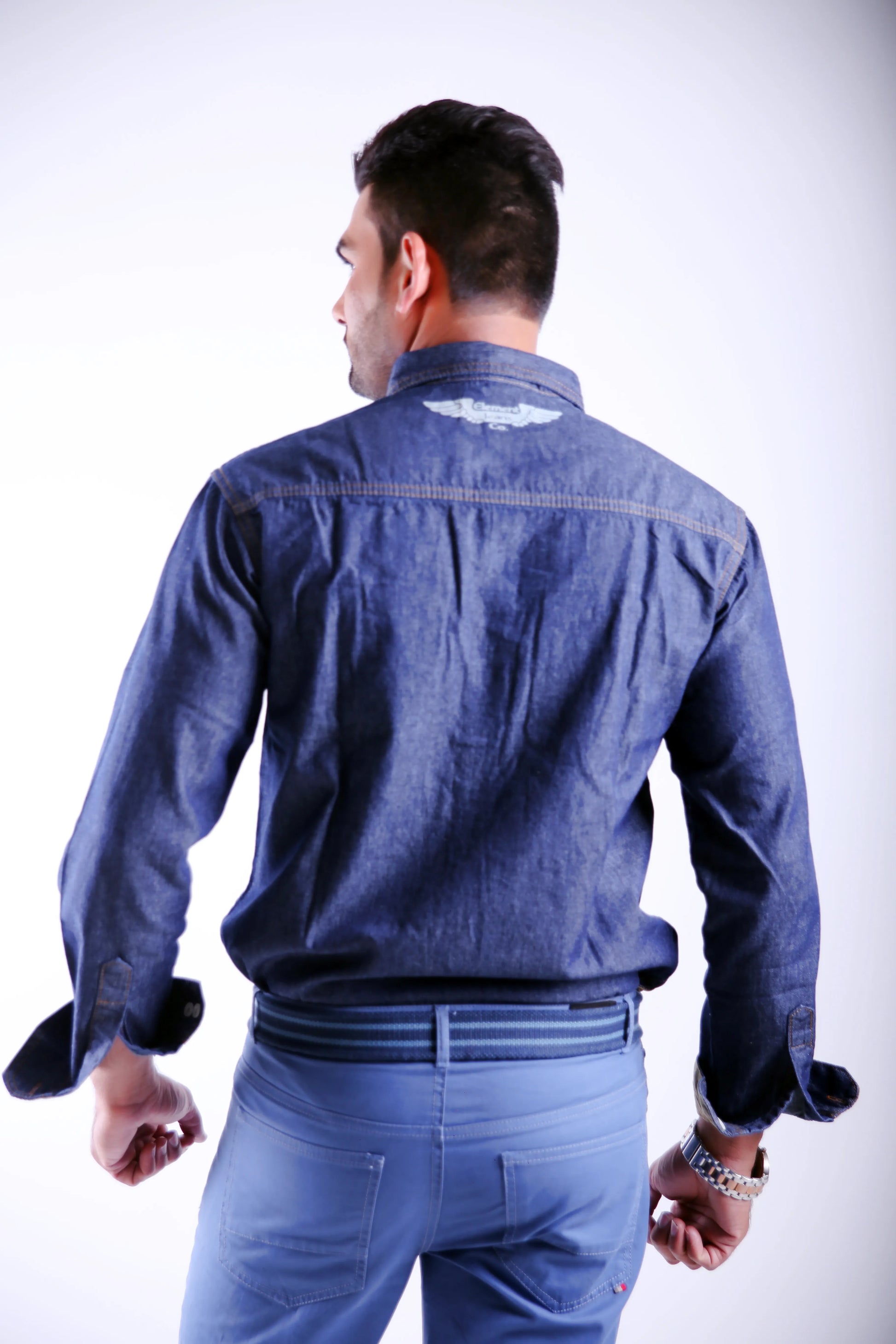 Man wearing a blue denim jacket and pants on a white background