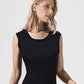 Woman wearing a black sleeveless bodysuit against a white background