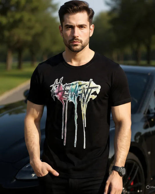 Man wearing a black t-shirt with colorful graphics and text, standing outdoors.