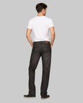 Man wearing a white t-shirt and black jeans on a gray background