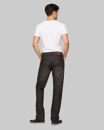 Man wearing a white t-shirt and black jeans on a gray background