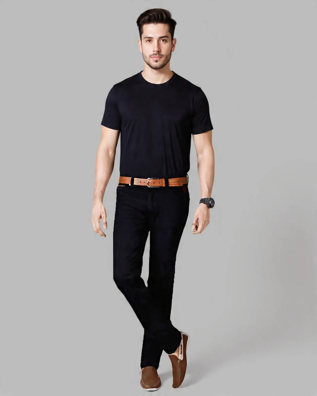 Person wearing black pants with a brown belt and shoes on a gray background