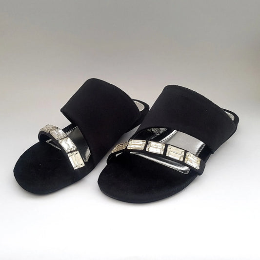 Black sandals with silver embellishments on a white background