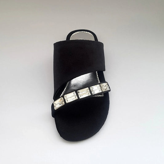 Black sandal with crystal embellishments on a light gray background