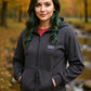 Woman wearing a black hoodie with a logo in an autumn setting