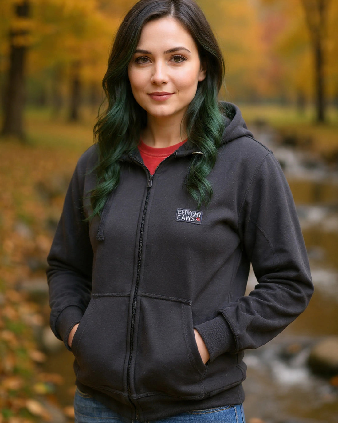 Man wearing a black hoodie with a logo in an autumn setting