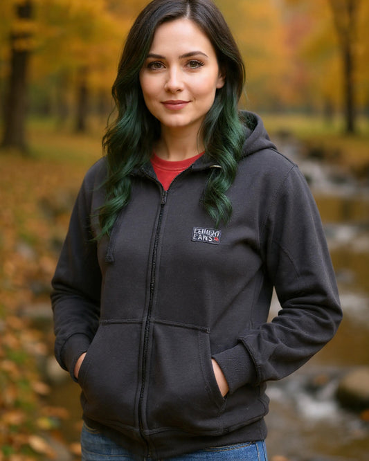 Woman wearing a black hoodie with a logo in an autumn setting