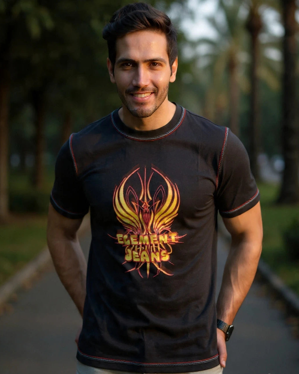Man wearing a black t-shirt with a colorful logo outdoors