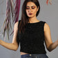 Woman wearing a black sleeveless top with a gray background
