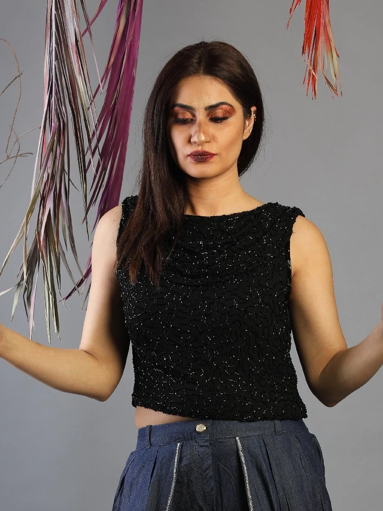 Woman wearing a black sleeveless top with a gray background