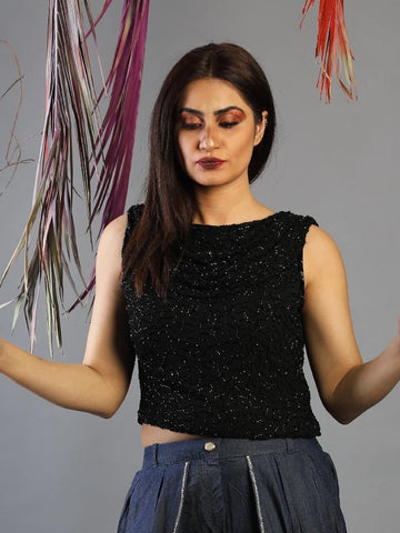 Woman wearing a black sleeveless top with a gray background
