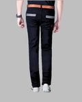 Person wearing black pants with white stripes on a gray background
