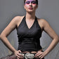 Woman wearing a black top with a silver belt against a gray background