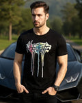 Man wearing a black t-shirt with colorful graphic design in front of a sports car.