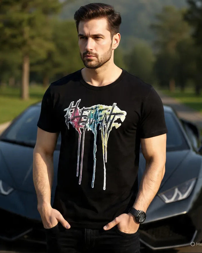 Man wearing a black t-shirt with colorful graphic design in front of a sports car.