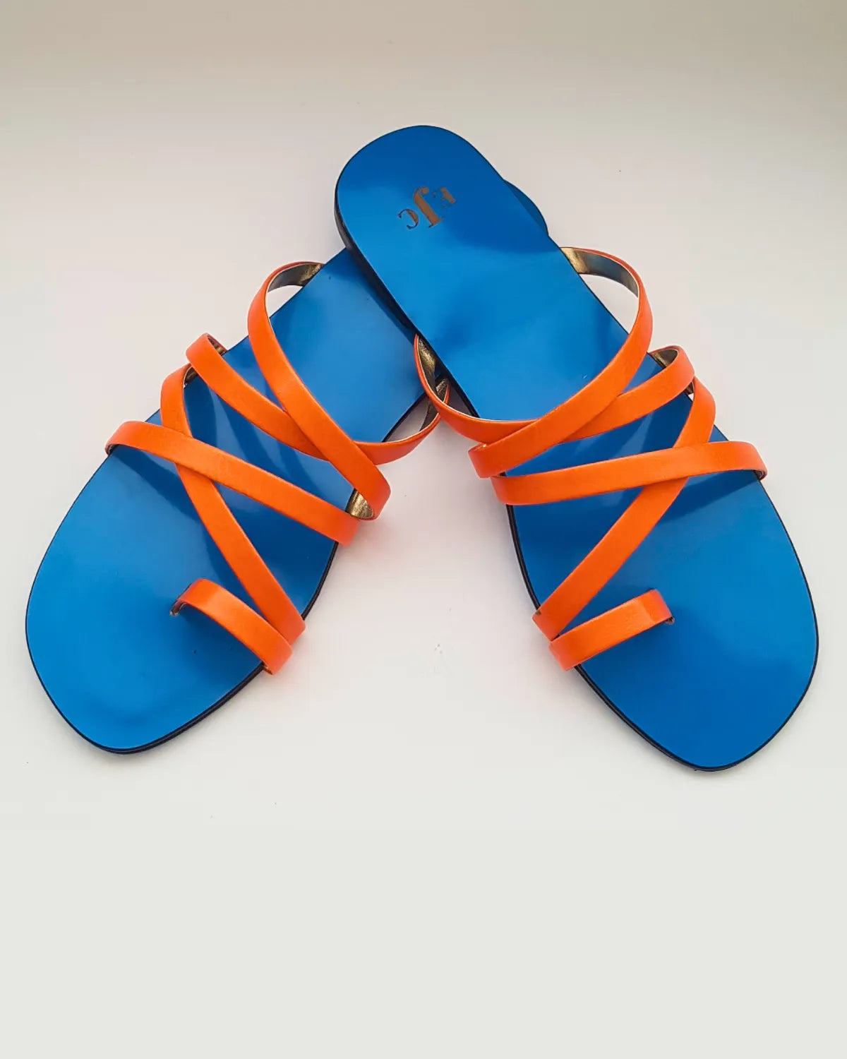 Blue sandals with orange straps on a white background