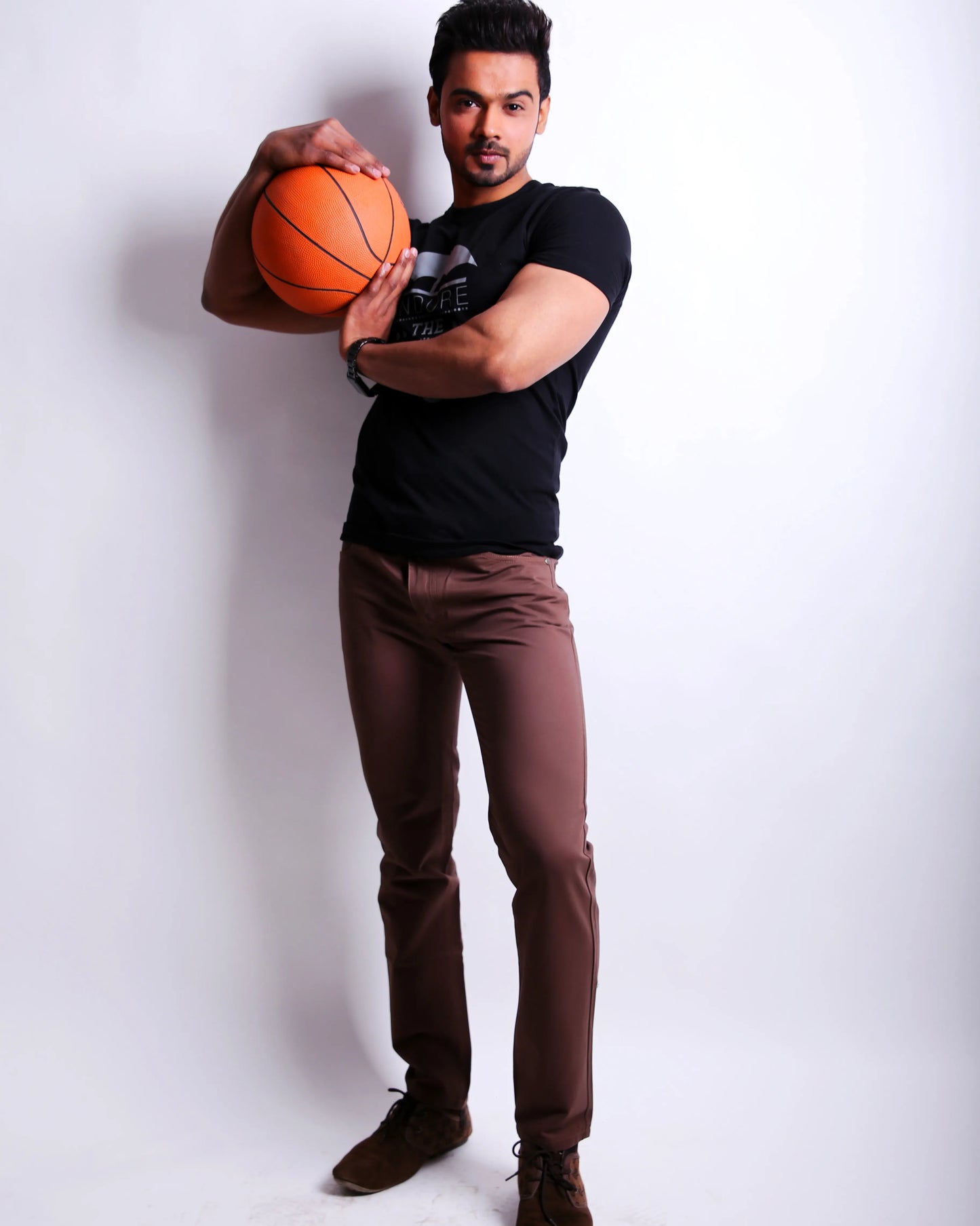 Man holding a basketball against a white background
