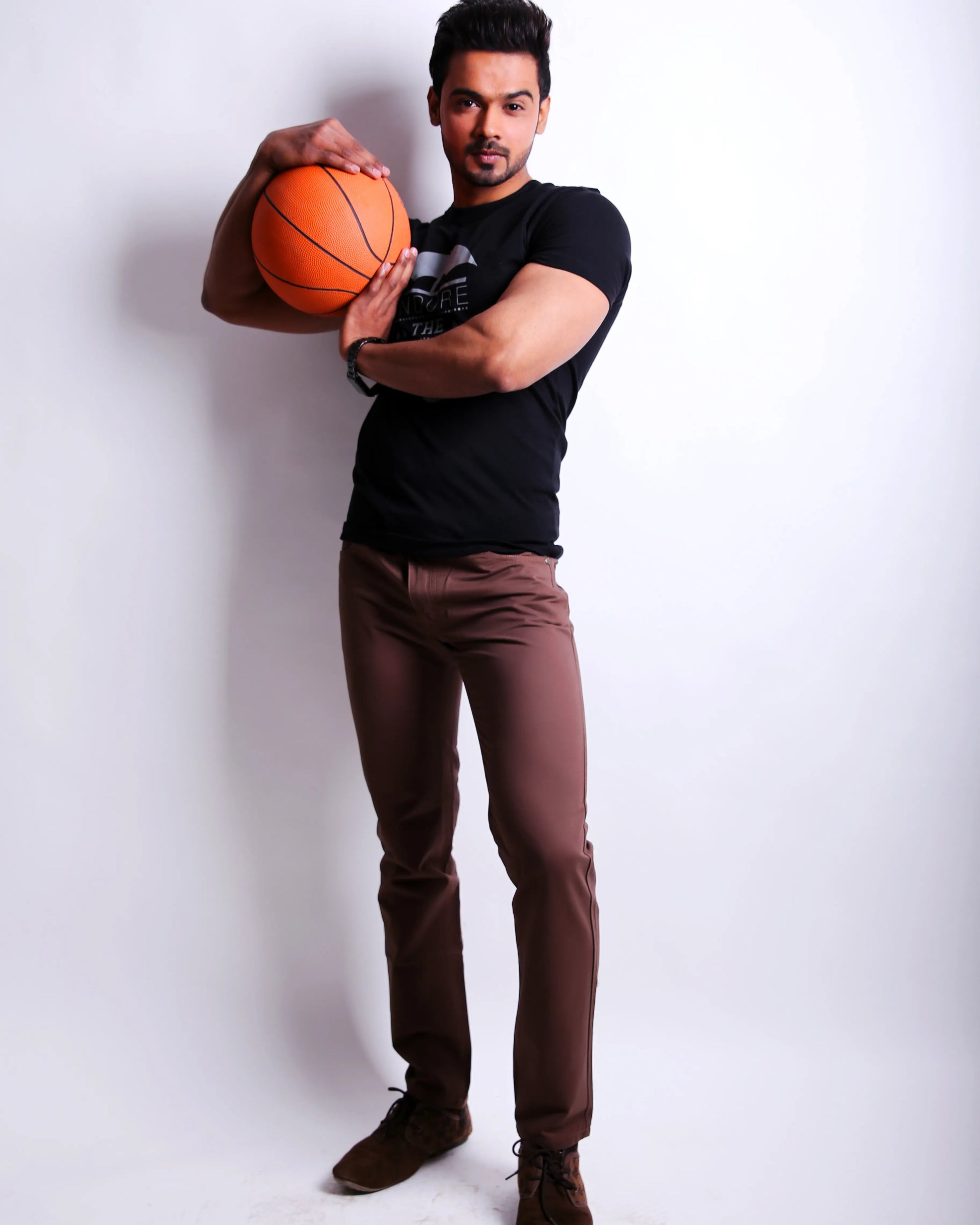Man holding a basketball against a white background