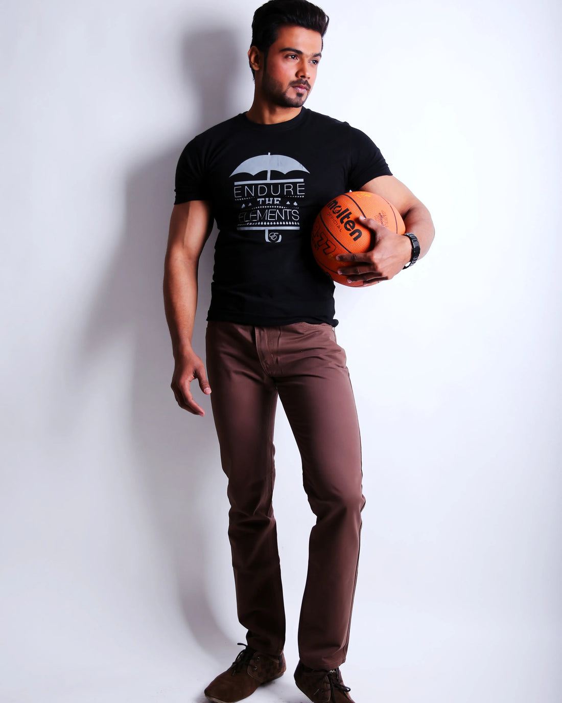 Man holding a basketball against a white background