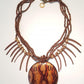 A brown wooden pendant necklace with multiple bead strings and an adjustable closure.