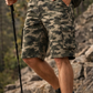 Person wearing camouflage shorts and hiking boots on a rocky trail