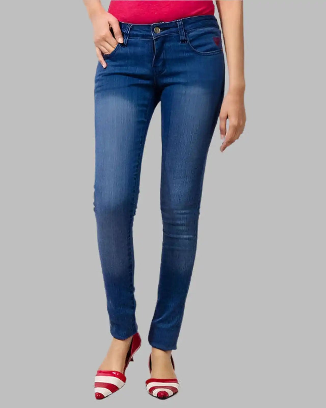 Blue jeans worn by a person on a gray background