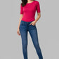 Woman wearing a pink top and blue jeans on a gray background