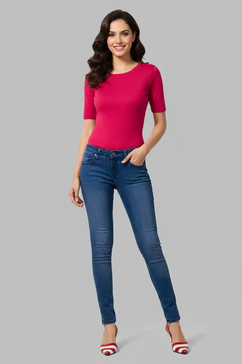 Woman wearing a pink top and blue jeans on a gray background