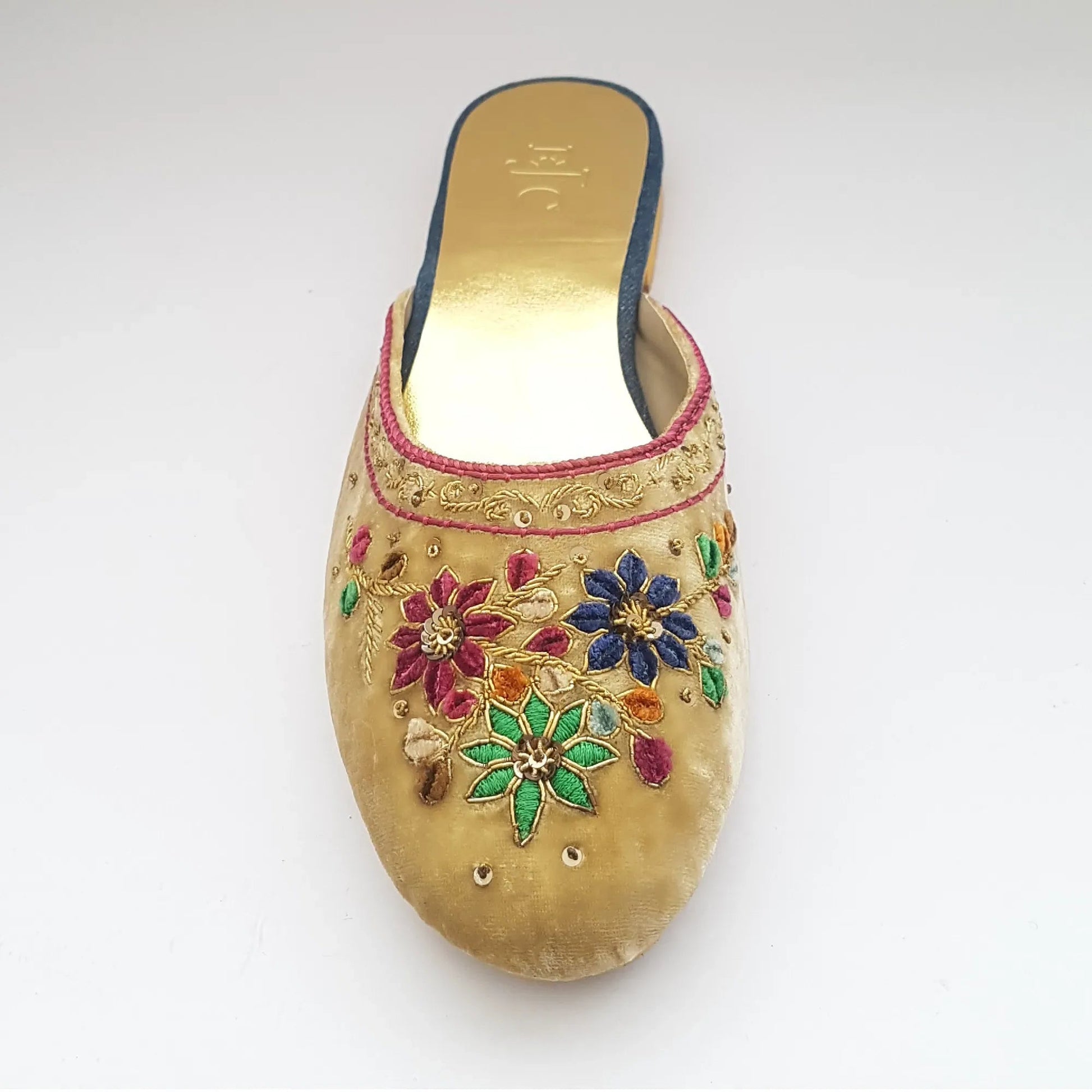 Decorative sandal with floral patterns and colorful stones on a white background