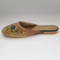 Pair of gold embroidered slippers with colorful floral designs on a light gray background