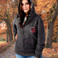 Woman wearing a dark gray hoodie with a logo in an autumn setting
