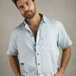 Man wearing a light blue shirt with a wooden background